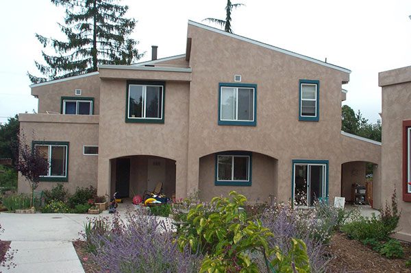 a tan house with green shutters